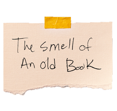 Handwritten note on textured paper reads, "The smell of an old book," secured with yellow tape.